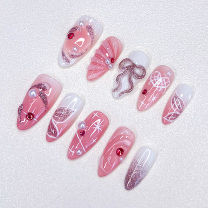 Elegant pink press-on nails with bow, star accents, and 3D details for a chic holiday look.