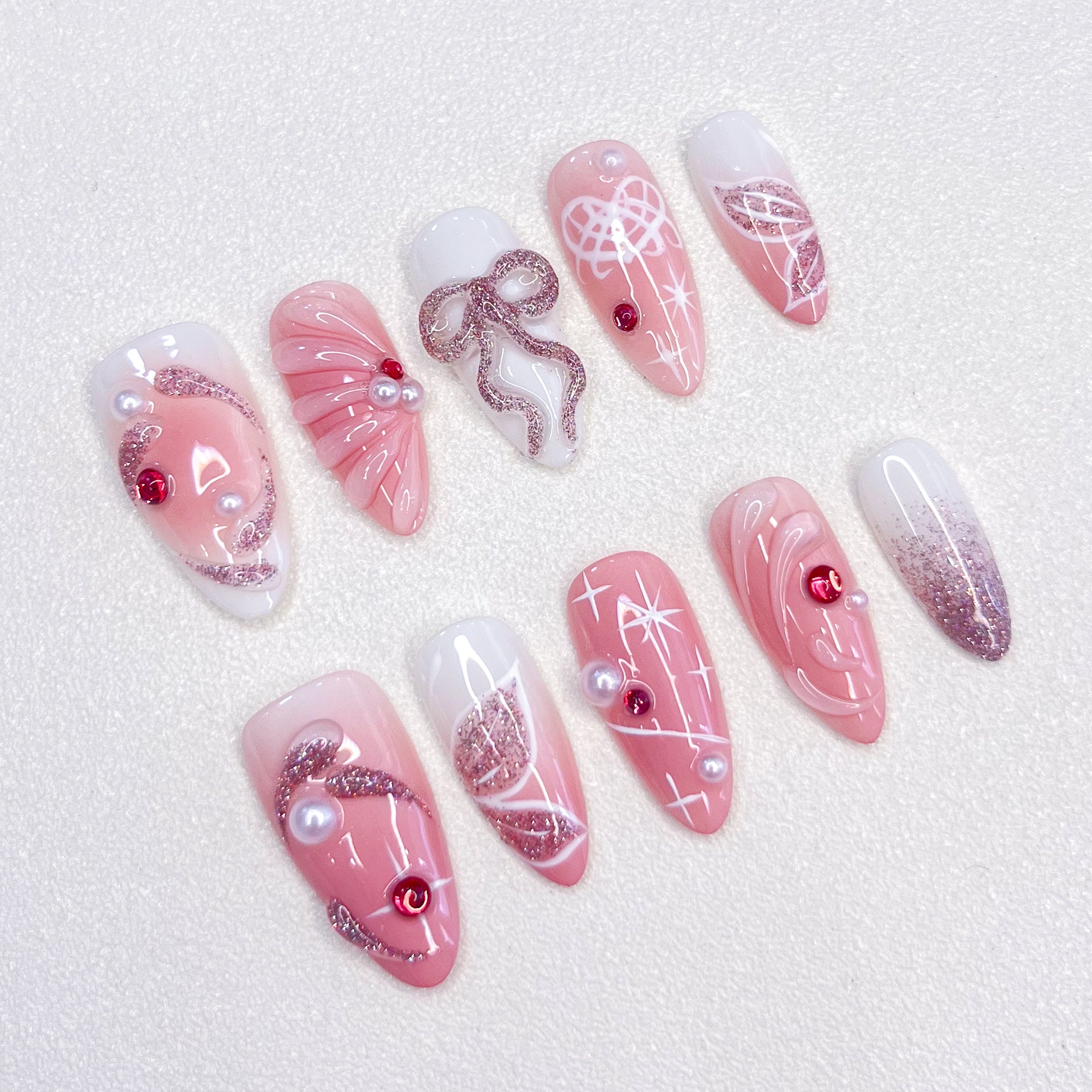 Pink Dream press-on nails with a pink design, embellished with pearls, bows, and glitter details for an elegant, romantic look.