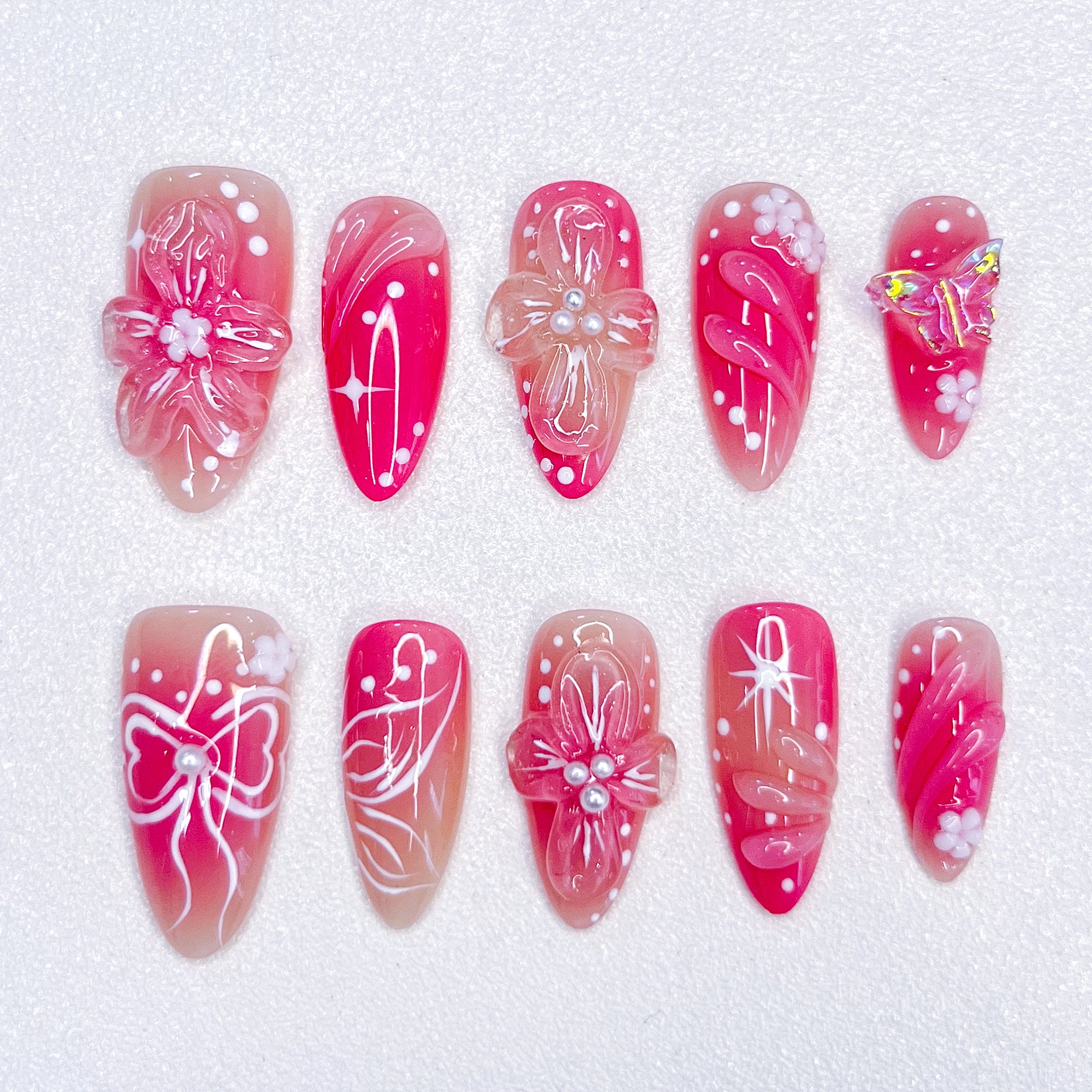 Sakura Elegance 3D pink press-on nails featuring cherry blossoms, butterflies, bows, and pearl details, creating a delicate and romantic style ideal for elegant occasions.