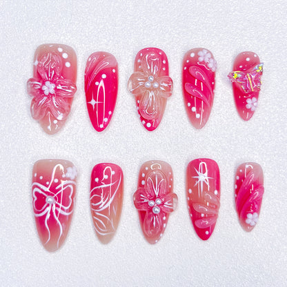 Sakura Elegance 3D pink press-on nails featuring cherry blossoms, butterflies, bows, and pearl details, creating a delicate and romantic style ideal for elegant occasions.