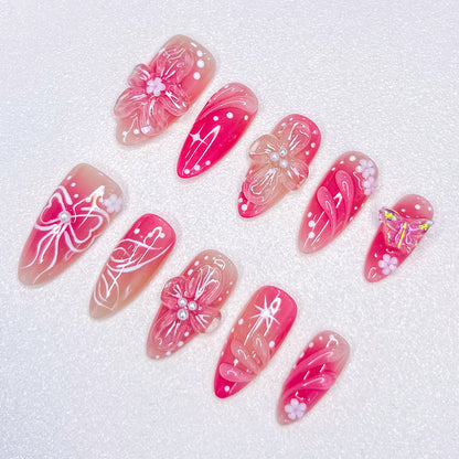 Sakura Elegance 3D pink press-on nails featuring cherry blossoms, butterflies, bows, and pearl details, creating a delicate and romantic style ideal for elegant occasions.