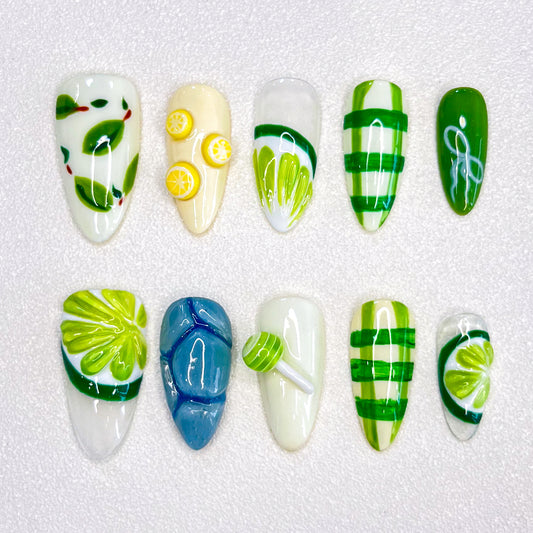 3D nail design featuring green leaves, lemons, and refreshing patterns in shades of green and yellow.