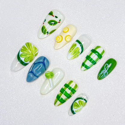 3D nail design featuring green leaves, lemons, and refreshing patterns in shades of green and yellow.