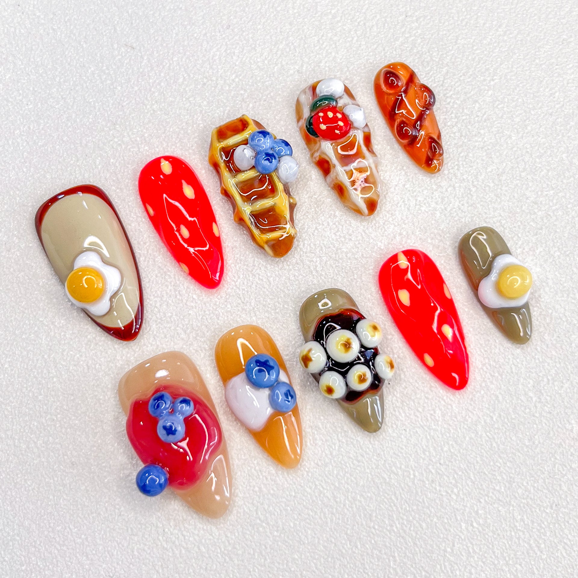 Brunch Bliss press-on nails with breakfast-inspired elements like eggs, waffles, and fruit toppings, perfect for food lovers.