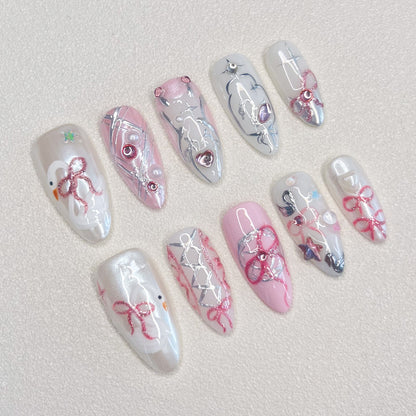 Ribbon Reverie press-on nails with pink tones, lace patterns, and ribbon accents, ideal for a soft, romantic appearance.