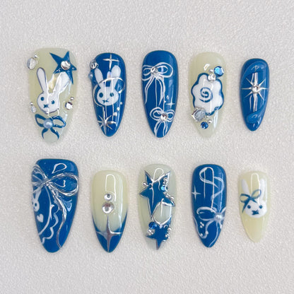 Lunar Bunny press-on nails with cute rabbit designs, star accents, and elegant ribbon details in blue and white tones.