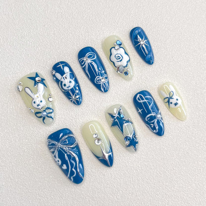 Lunar Bunny press-on nails with cute rabbit designs, star accents, and elegant ribbon details in blue and white tones.