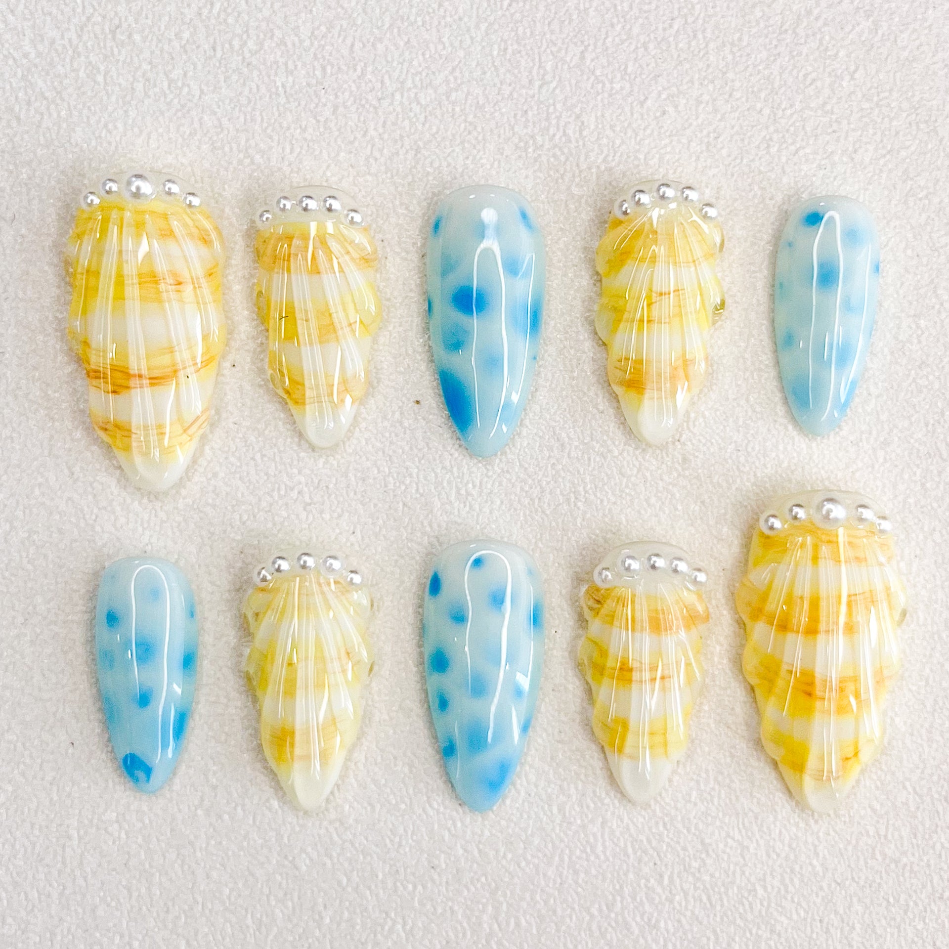 Pearl Shell press-on nails with seashell designs and gentle wave patterns, capturing the calming essence of the ocean.