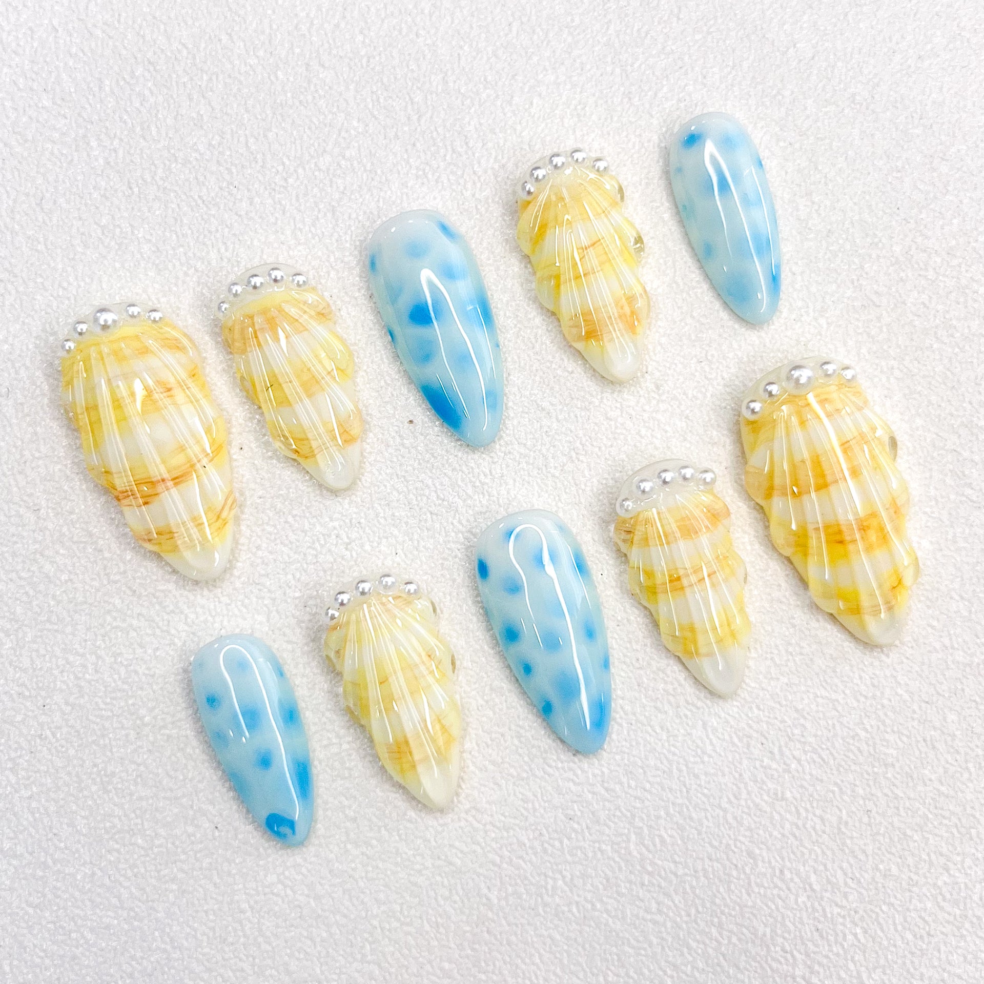 Pearl Shell press-on nails with seashell designs and gentle wave patterns, capturing the calming essence of the ocean.