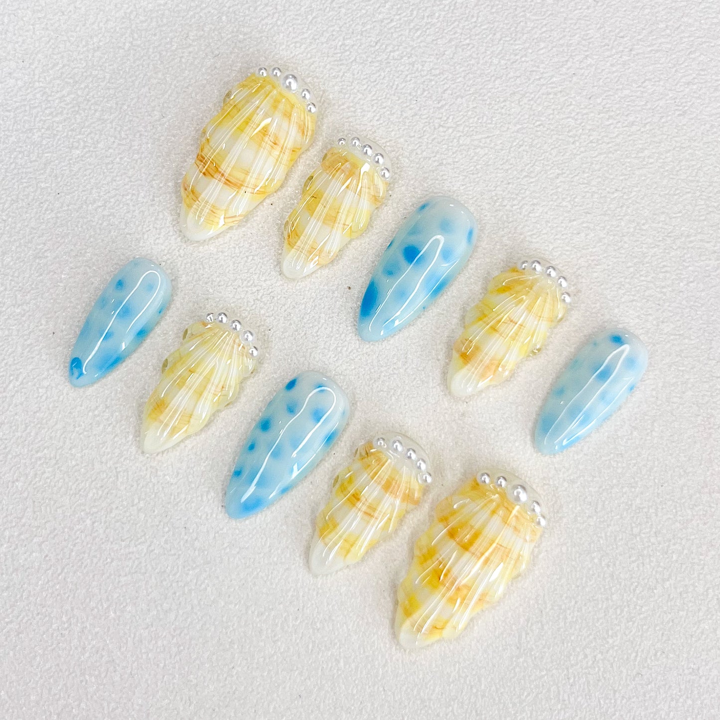 Pearl Shell  press-on nails with seashell designs and gentle wave patterns, capturing the calming essence of the ocean.