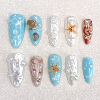 Ocean Pearls press-on nails featuring starfish, shells, and shimmering pearls for a chic, sea-inspired design.