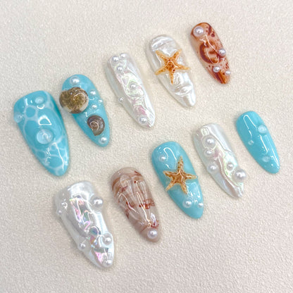 Ocean Pearls press-on nails featuring starfish, shells, and shimmering pearls for a chic, sea-inspired design.