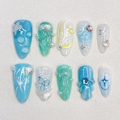 Mermaid’s Dream press-on nails with wave-like patterns and shimmering finishes in oceanic hues, ideal for a mystical style.