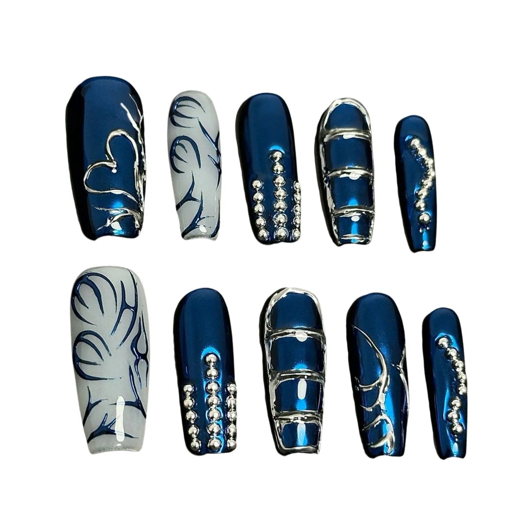 A press-on nail set featuring metallic blue bases, silver linework, and rhinestone details, creating an elegant, frosty winter-inspired design.