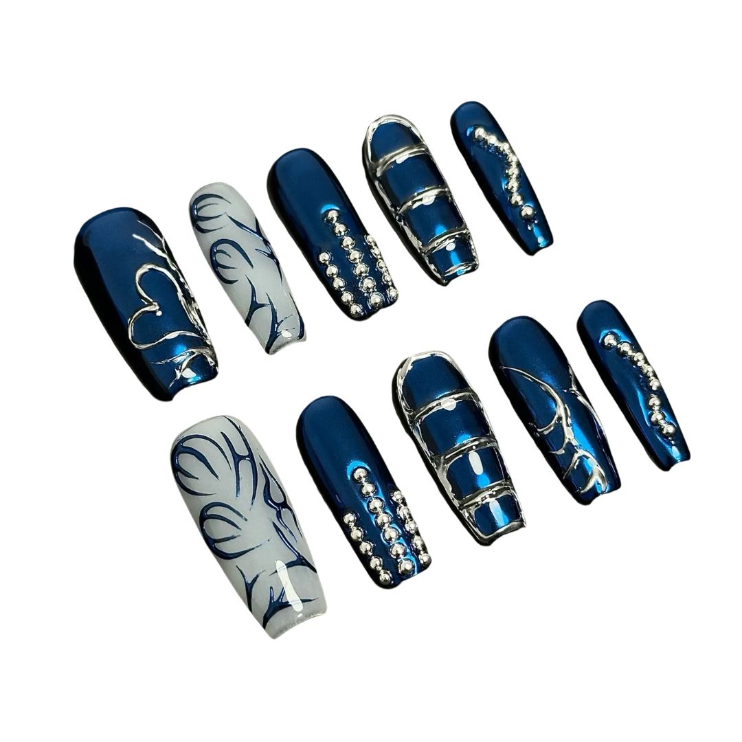 A press-on nail set featuring metallic blue bases, silver linework, and rhinestone details, creating an elegant, frosty winter-inspired design.