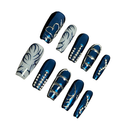 A press-on nail set featuring metallic blue bases, silver linework, and rhinestone details, creating an elegant, frosty winter-inspired design.