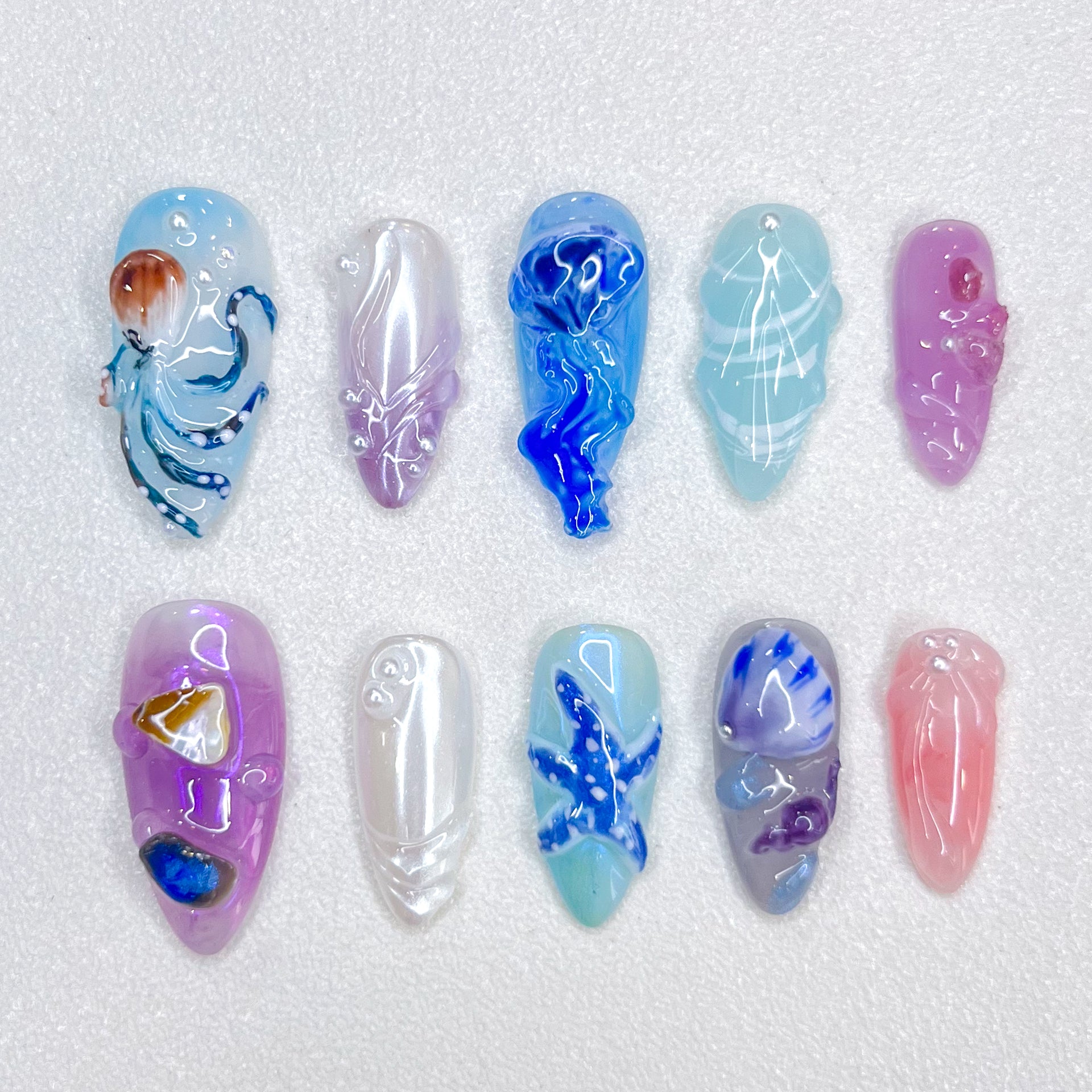 Deep Sea Dreams press-on nails with jellyfish, octopus, and starfish details in blue and purple tones, perfect for an oceanic, dreamy vibe.