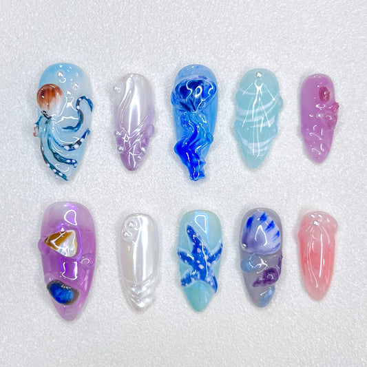 Deep Sea Dreams press-on nails with jellyfish, octopus, and starfish details in blue and purple tones, perfect for an oceanic, dreamy vibe.