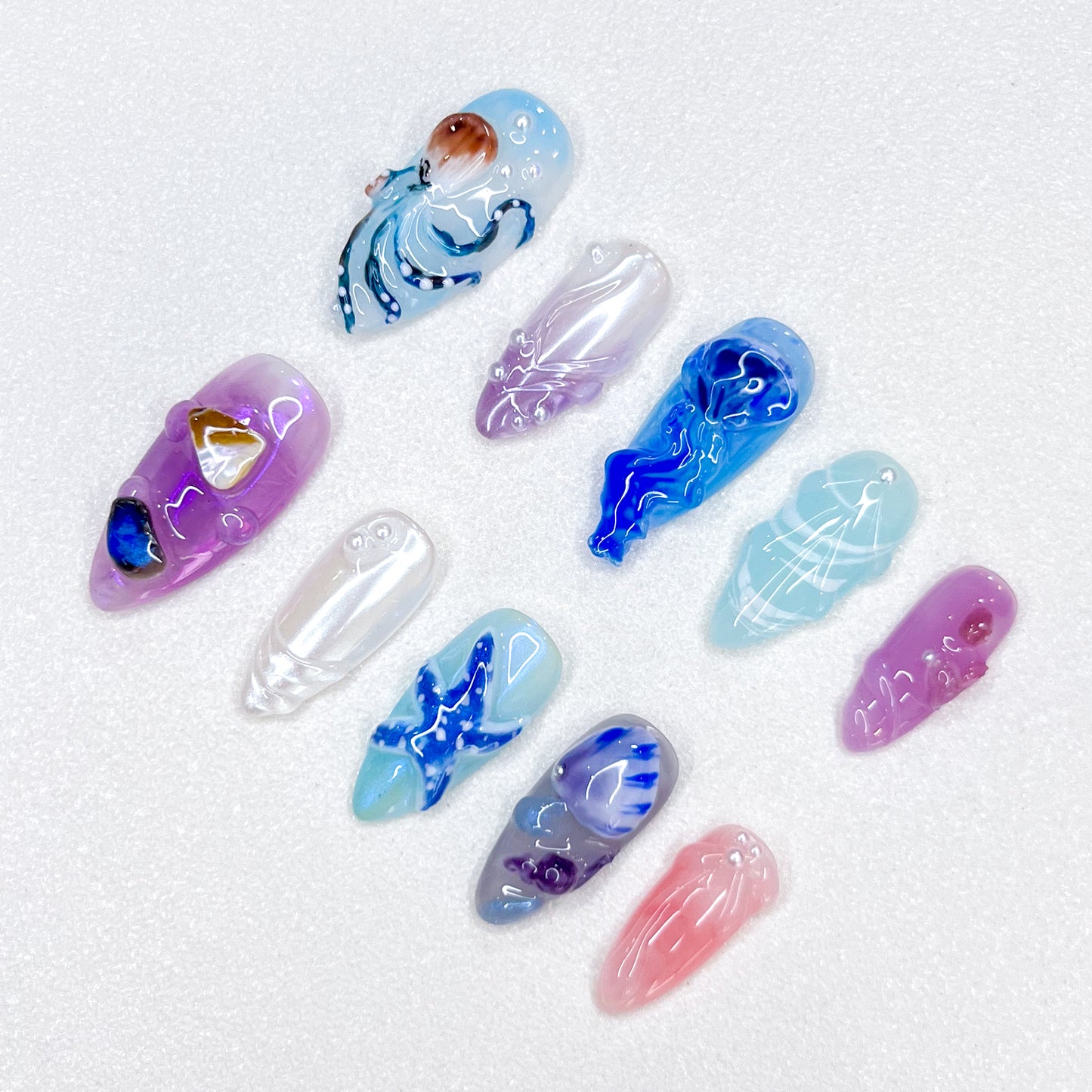 Deep Sea Dreams press-on nails with jellyfish, octopus, and starfish details in blue and purple tones, perfect for an oceanic, dreamy vibe.