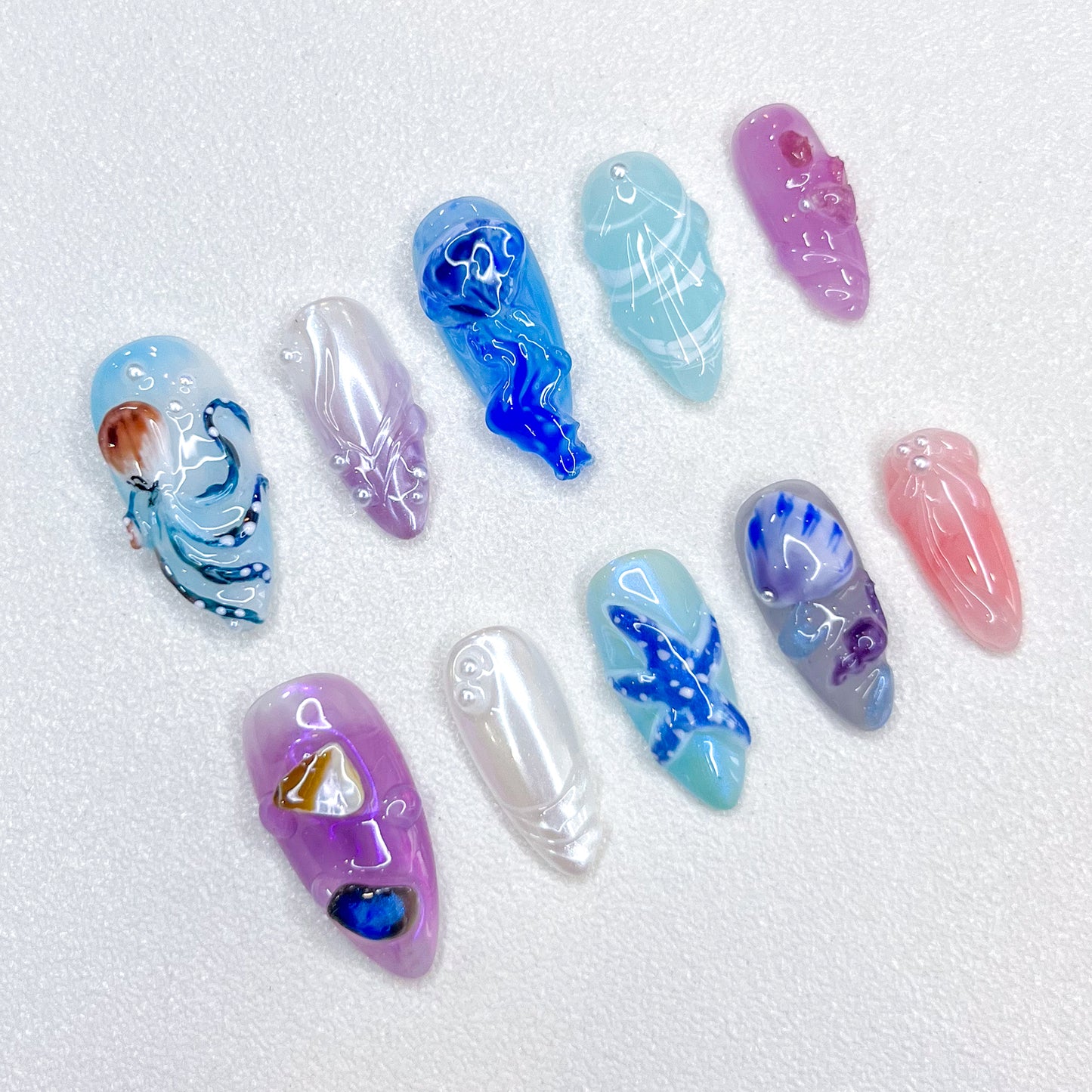 Deep Sea Dreams press-on nails with jellyfish, octopus, and starfish details in blue and purple tones, perfect for an oceanic, dreamy vibe.