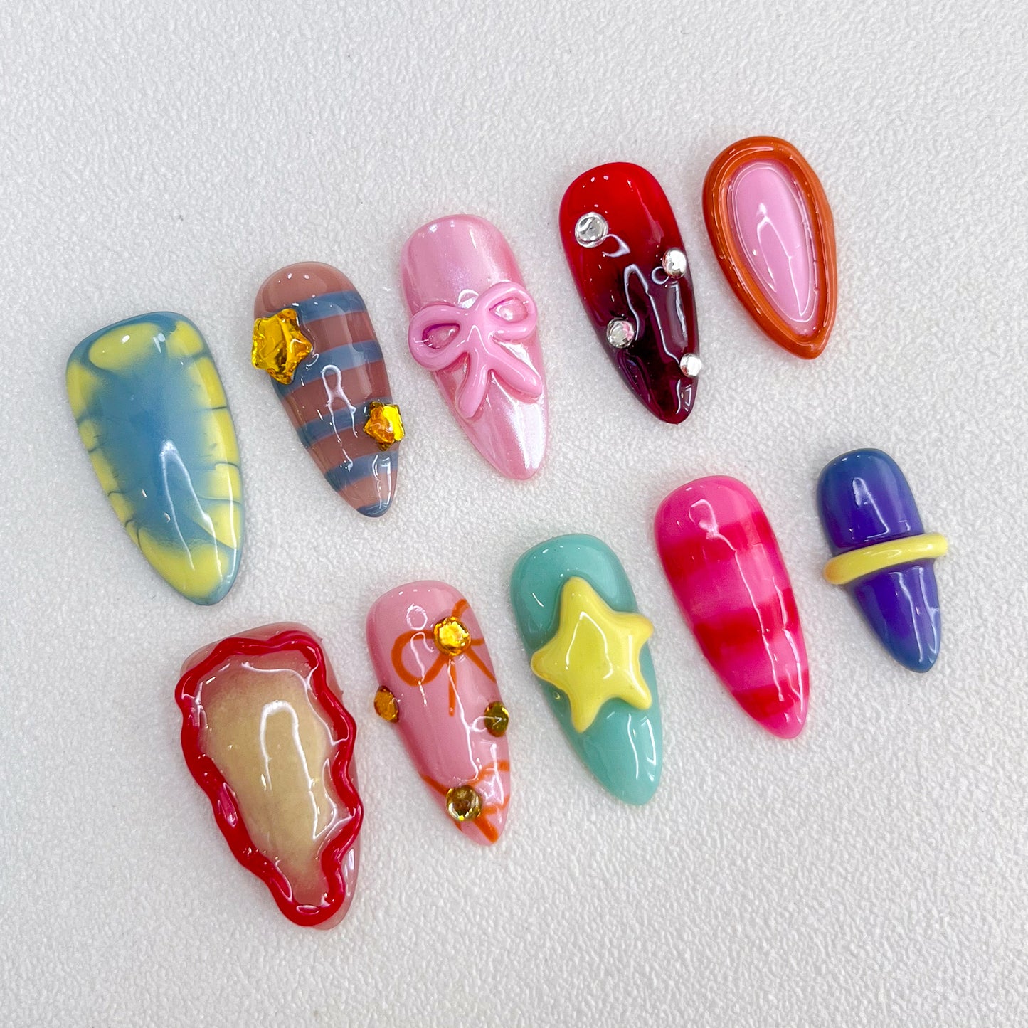 Candy Delight press-on nails with bright colors, 3D bows, and star details for a cute, playful, and sweet design.