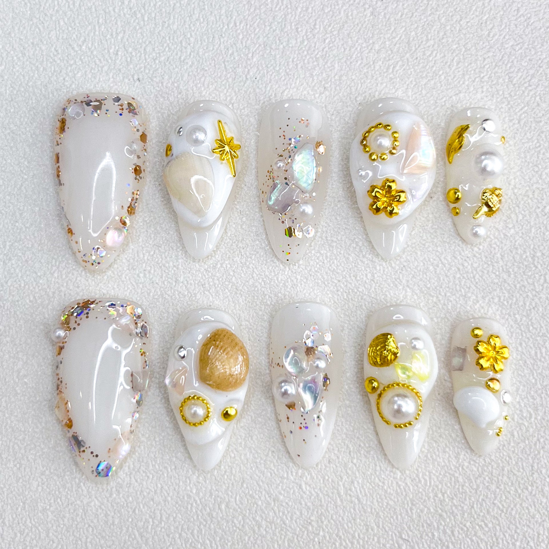 Golden Seashell press-on nails with gold accents, pearls, and seashell designs, capturing a chic and elegant coastal charm.