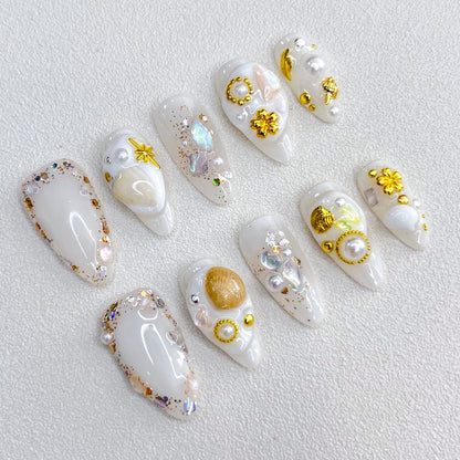 Golden Seashell press-on nails with gold accents, pearls, and seashell designs, capturing a chic and elegant coastal charm.