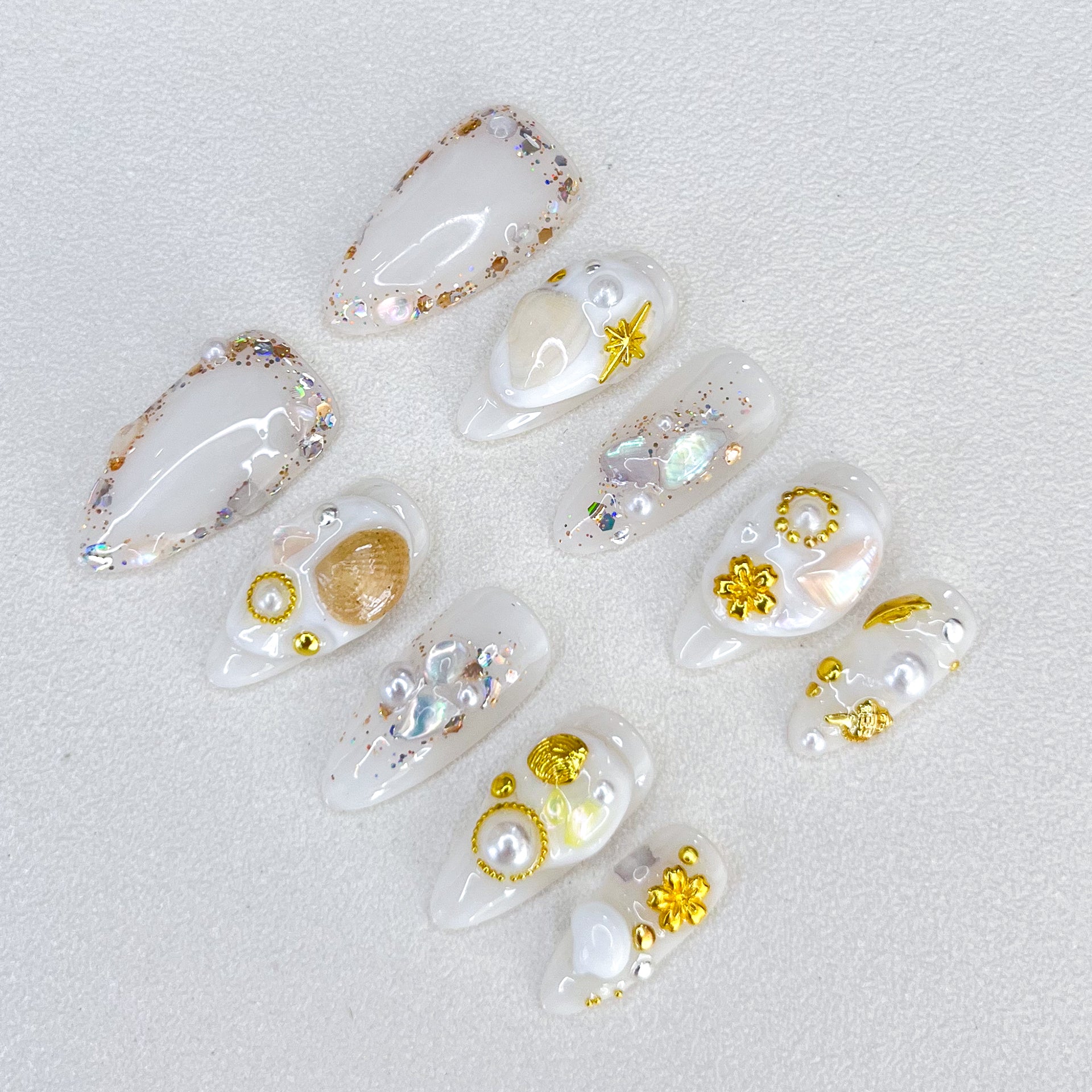 Golden Seashell press-on nails with gold accents, pearls, and seashell designs, capturing a chic and elegant coastal charm.