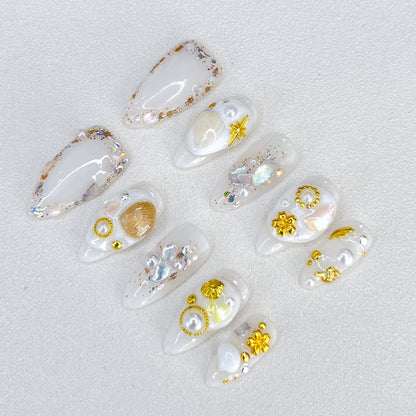 Golden Seashell press-on nails with gold accents, pearls, and seashell designs, capturing a chic and elegant coastal charm.