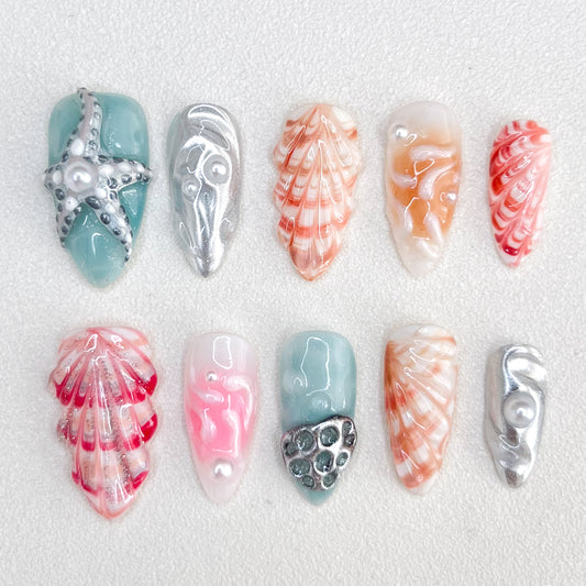 Oceanic Elegance press-on nails with seashell patterns, starfish accents, and ocean-inspired colors for a sophisticated seaside style.