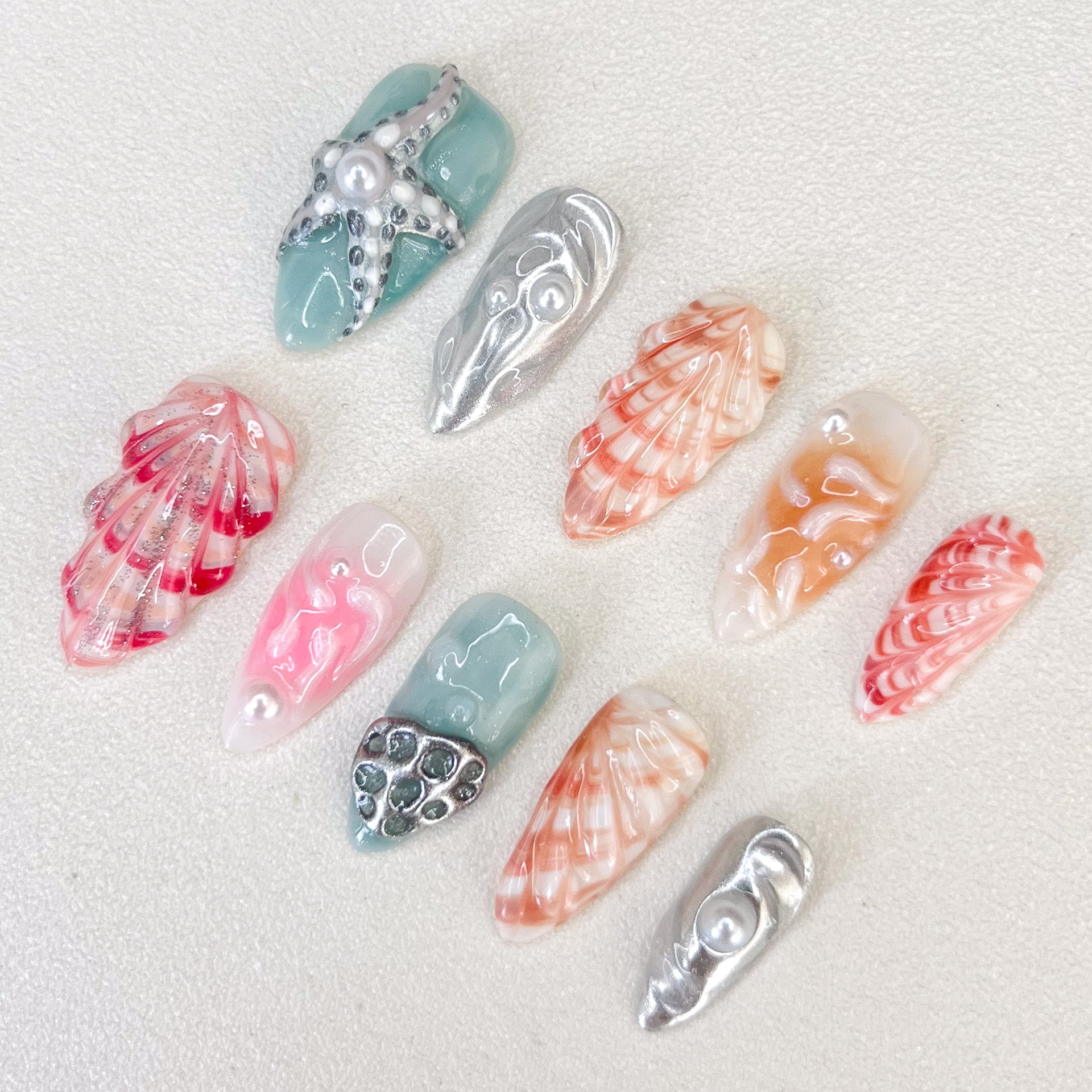 Oceanic Elegance press-on nails with seashell patterns, starfish accents, and ocean-inspired colors for a sophisticated seaside style.