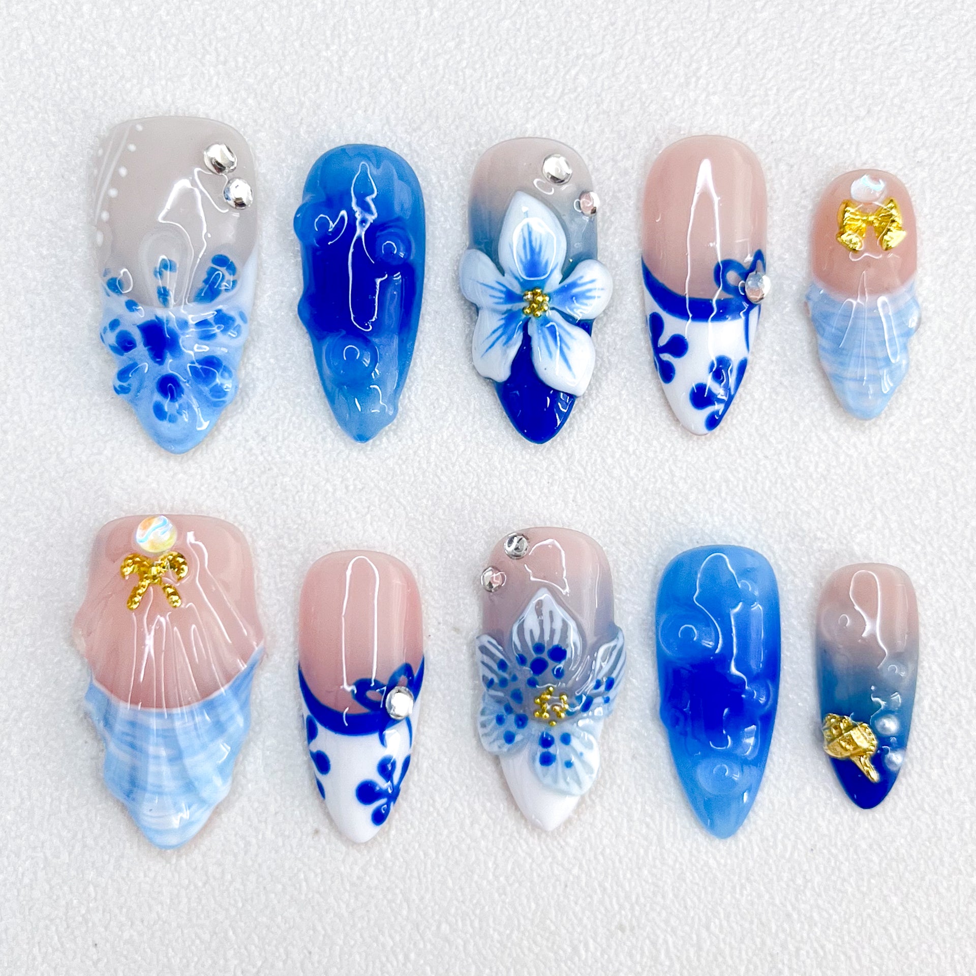 Celestial Bloom press-on nails with intricate blue floral designs and white porcelain-inspired patterns for a graceful, nature-inspired style.