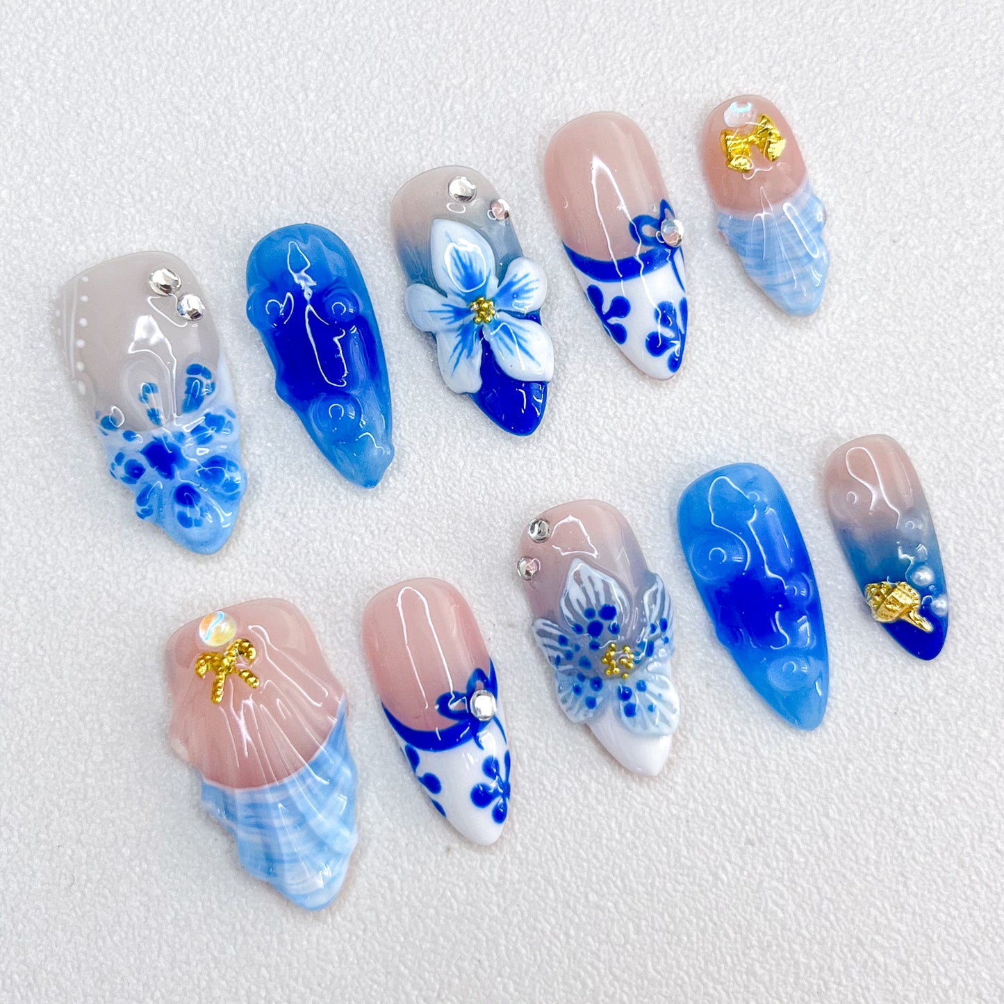 Celestial Bloom press-on nails with intricate blue floral designs and white porcelain-inspired patterns for a graceful, nature-inspired style.