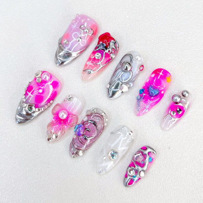 Galactic Glow press-on nails with abstract silver and pink patterns, accented with shimmering 3D details for a dazzling, cosmic look.