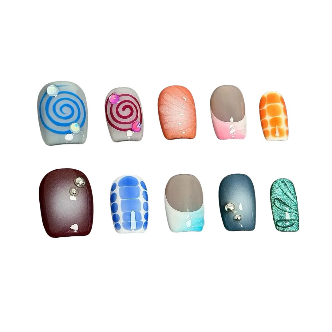 A press-on nail set with colorful spirals, gradient effects, geometric patterns, and gemstone accents, offering a playful and creative design.