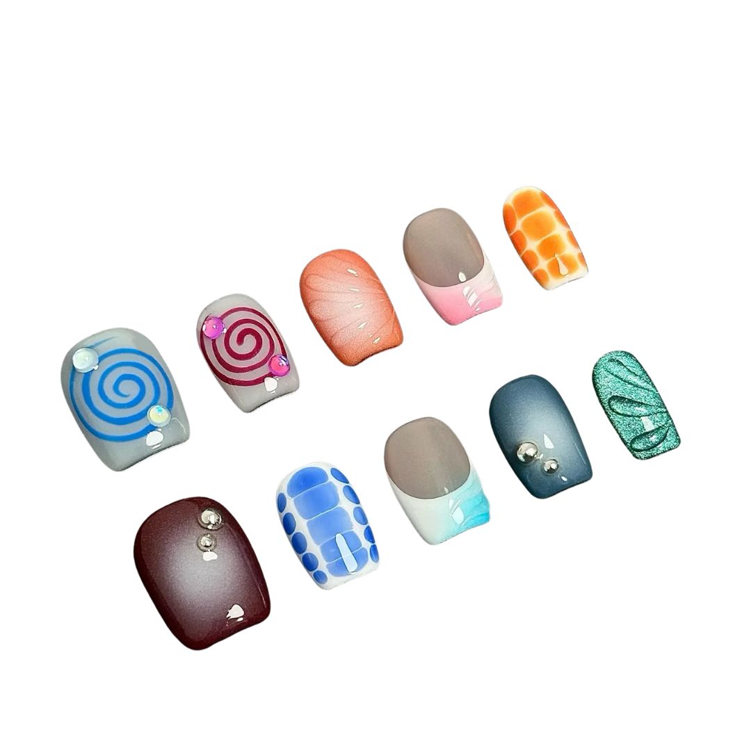 A press-on nail set with colorful spirals, gradient effects, geometric patterns, and gemstone accents, offering a playful and creative design.