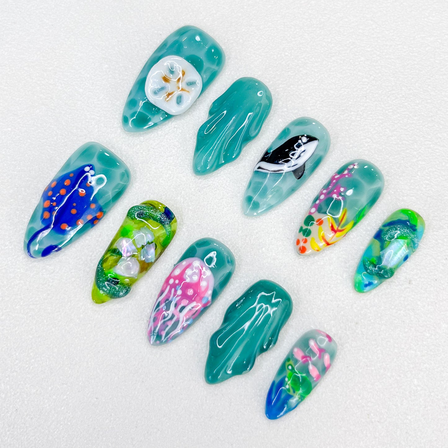 Jellyfish Dreams press-on nails with jellyfish and coral details, paired with vibrant teal tones for a unique oceanic style.