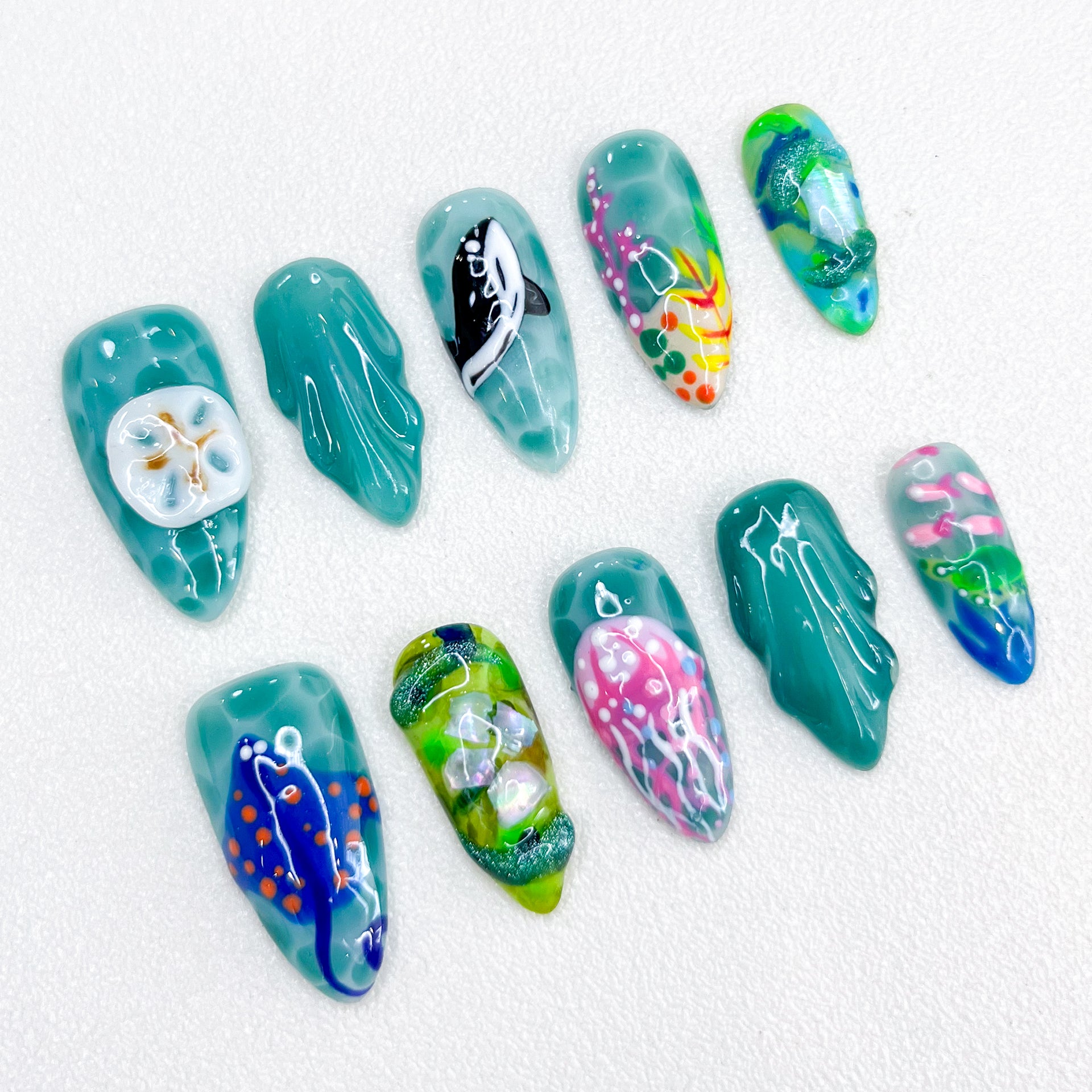 Jellyfish Dreams press-on nails with jellyfish and coral details, paired with vibrant teal tones for a unique oceanic style.