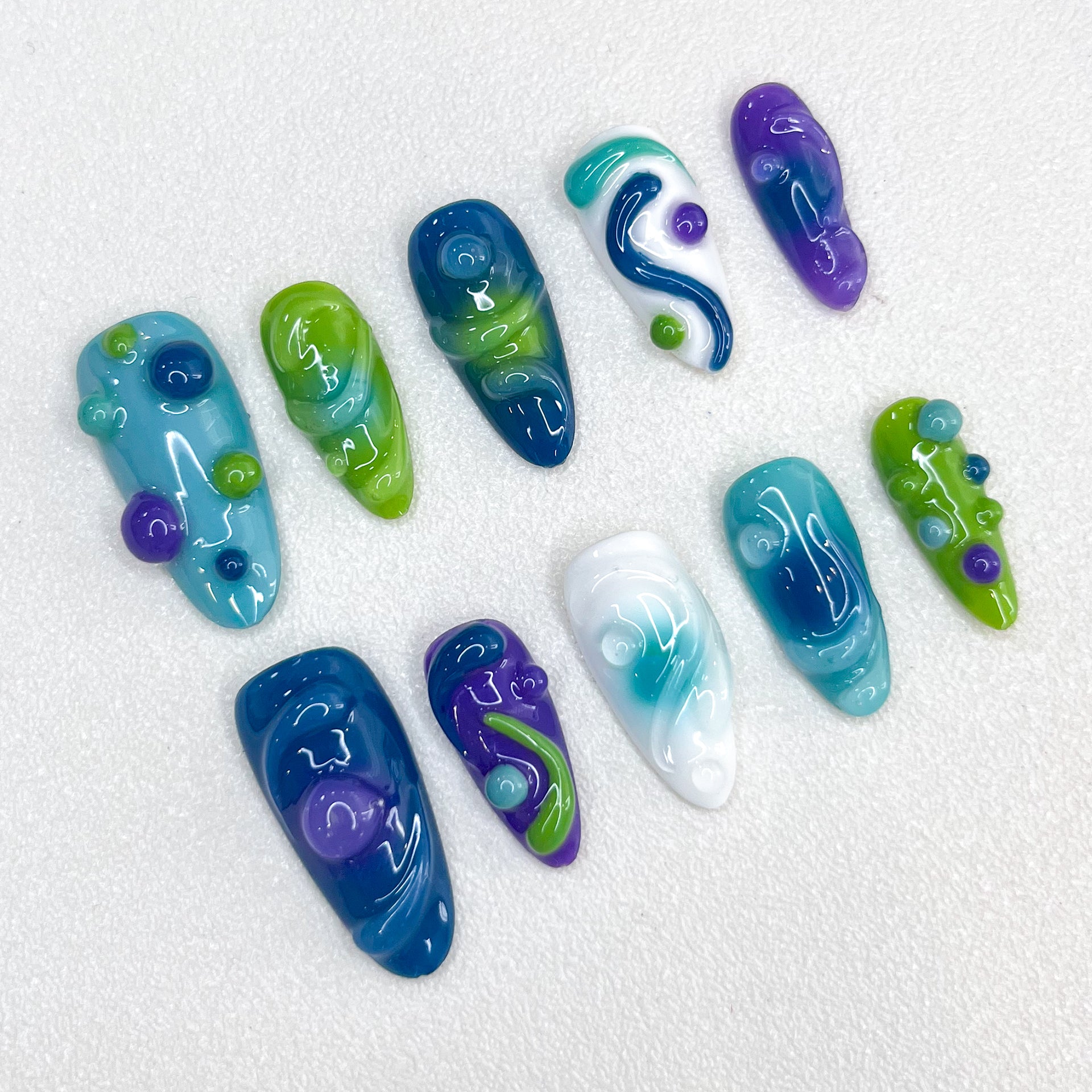 Ocean Swirl press-on nails with swirling aquatic patterns in bold oceanic colors, perfect for marine lovers.