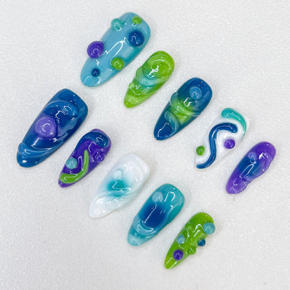 Ocean Swirl press-on nails with swirling aquatic patterns in bold oceanic colors, perfect for marine lovers.