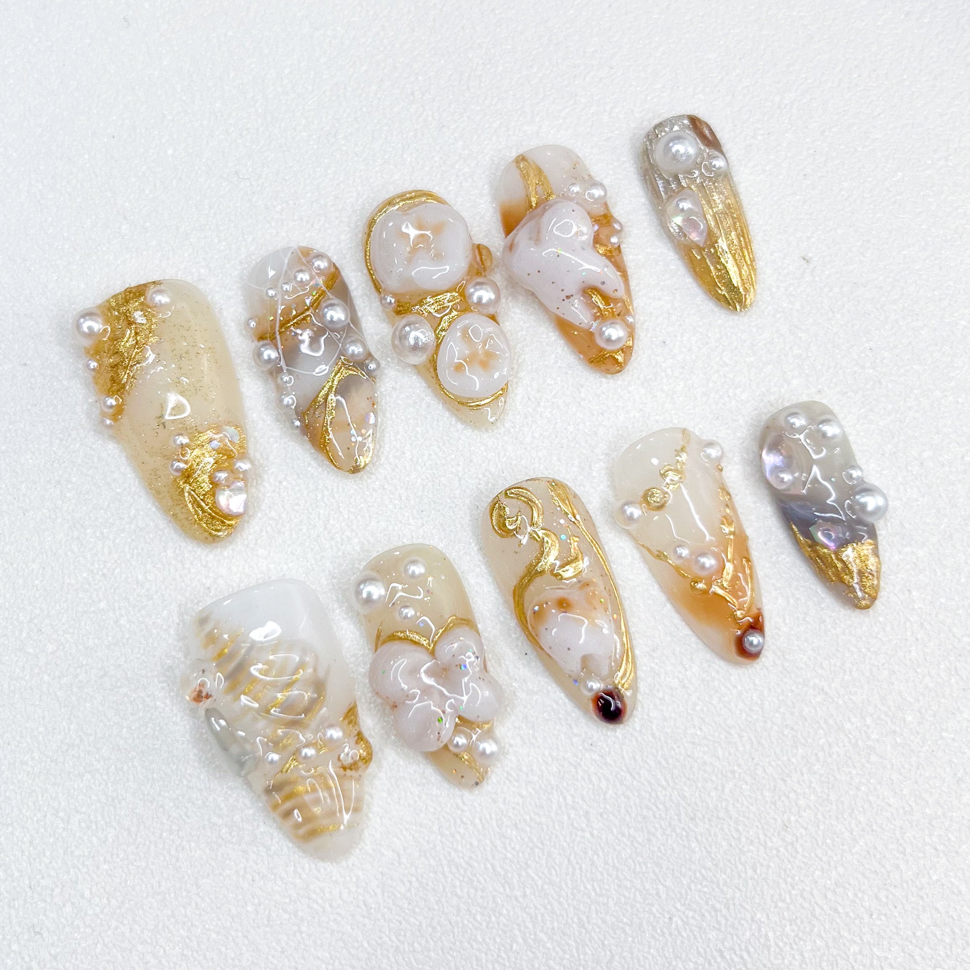 Golden Pearl press-on nails with gold details, pearl accents, and a refined aesthetic for timeless elegance.