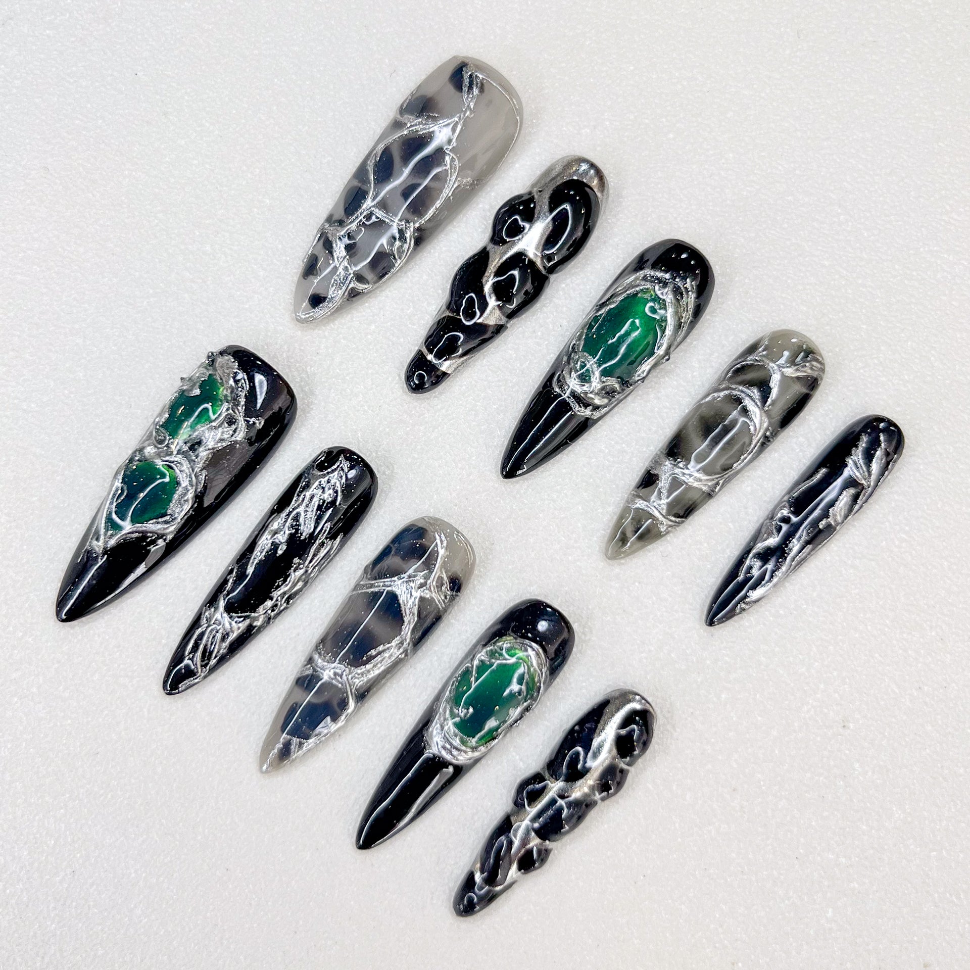 Midnight Web press-on nails with intricate black and silver patterns, accented with green details for a bold, enigmatic look.