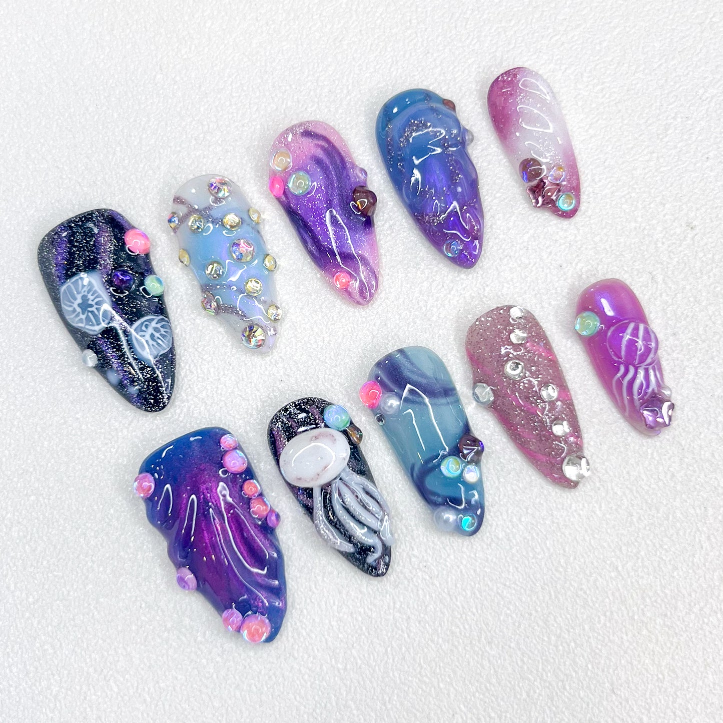 Nebula Glow press-on nails with galaxy-inspired designs, vibrant swirls, and intricate jellyfish accents for a mystical vibe.