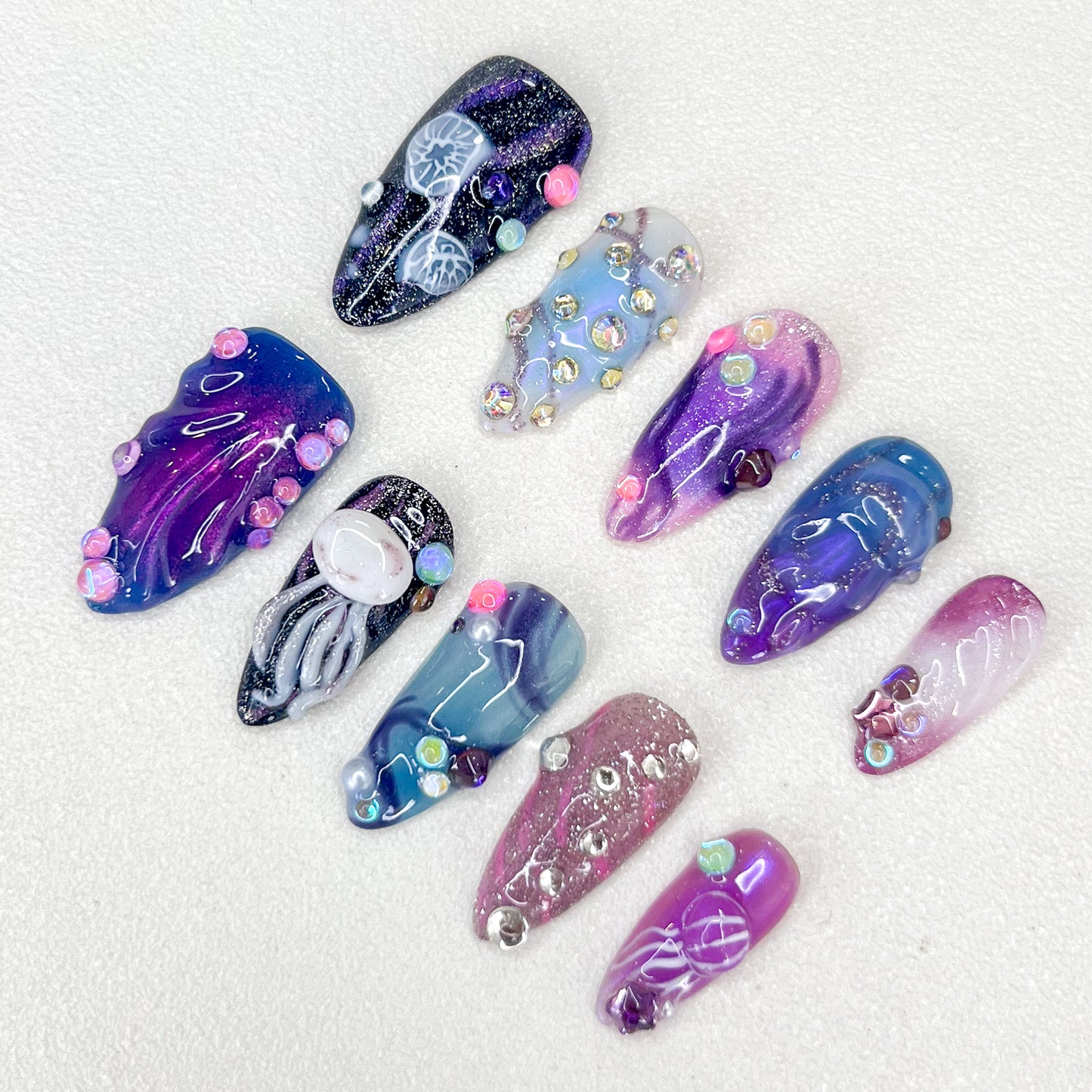 Nebula Glow press-on nails with galaxy-inspired designs, vibrant swirls, and intricate jellyfish accents for a mystical vibe.