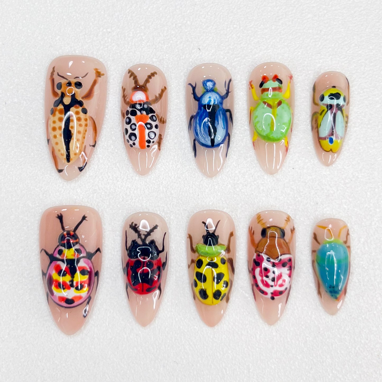 Beetle Garden press-on nails with intricate beetle artwork and vibrant natural hues for a daring look.