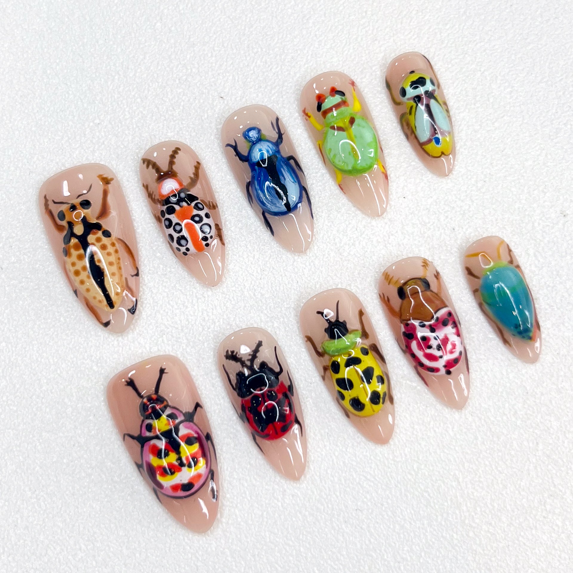 Beetle Garden press-on nails with intricate beetle artwork and vibrant natural hues for a daring look.