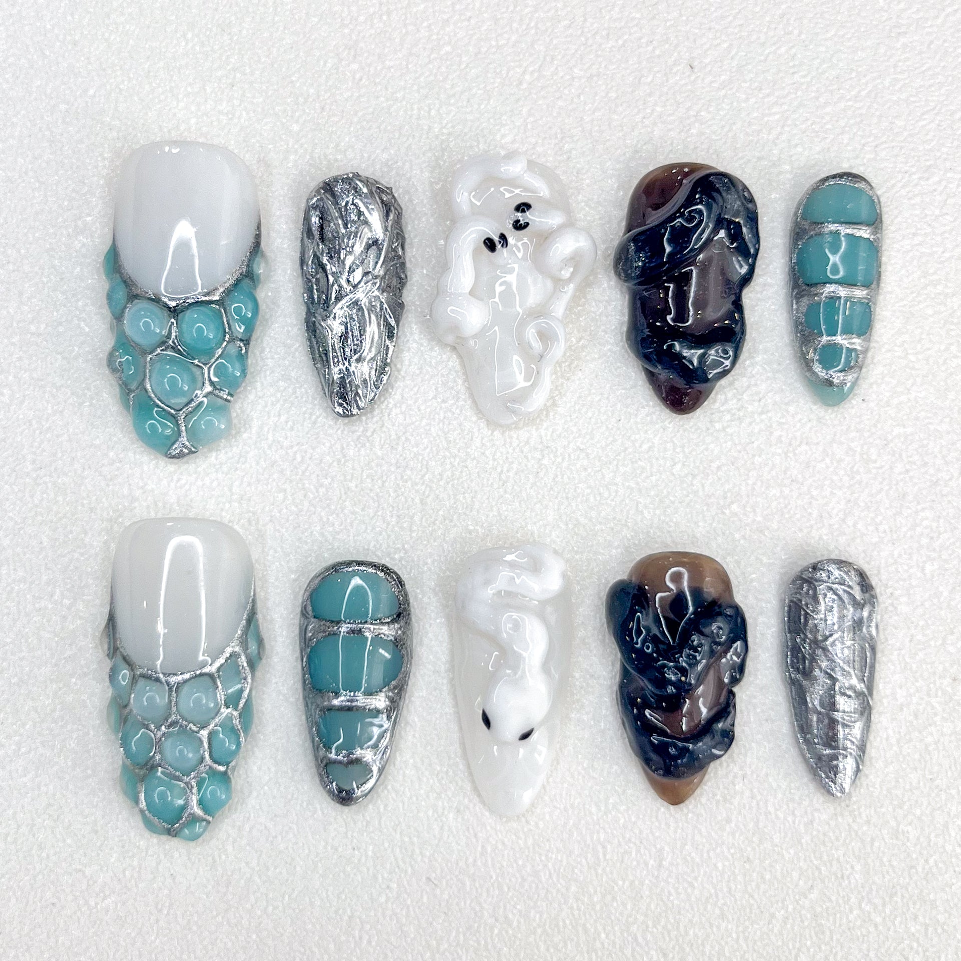 Serpent's Embrace press-on nails with snake-inspired patterns and metallic tones, perfect for a bold and mystical look.