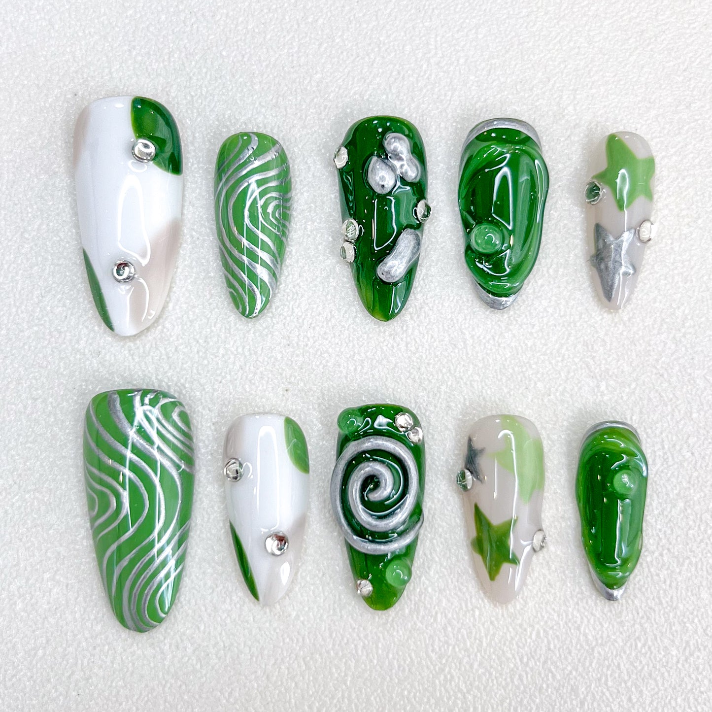 Verdant Whispers press-on nails with clean lines and green hues, accented with intricate spiral and metallic details.