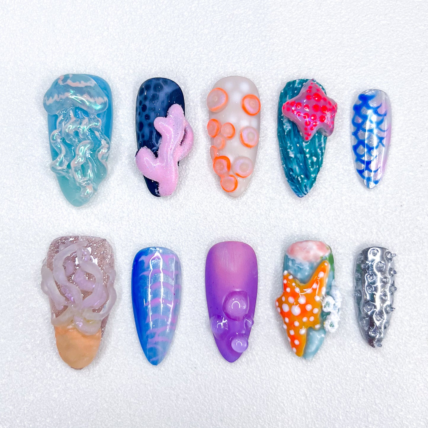 A unique ocean-themed nail art set by Lris Nails featuring 3D jellyfish, coral reefs, starfish, and ocean textures. Vibrant colors and intricate marine-inspired designs bring underwater beauty to your nails.