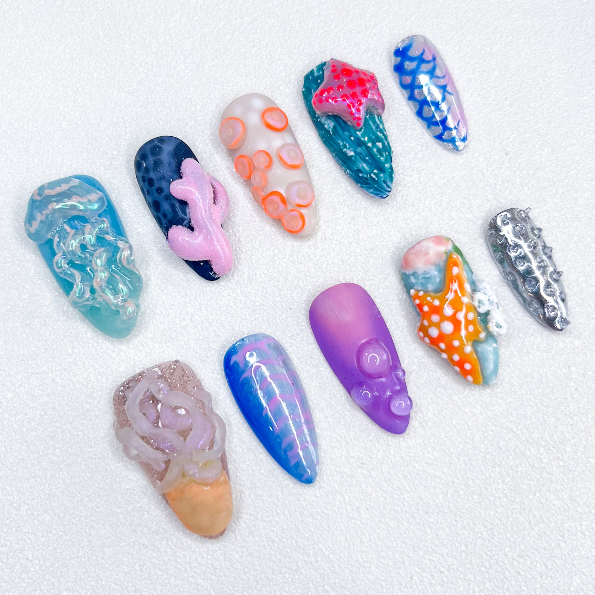 A unique ocean-themed nail art set by Lris Nails featuring 3D jellyfish, coral reefs, starfish, and ocean textures. Vibrant colors and intricate marine-inspired designs bring underwater beauty to your nails.